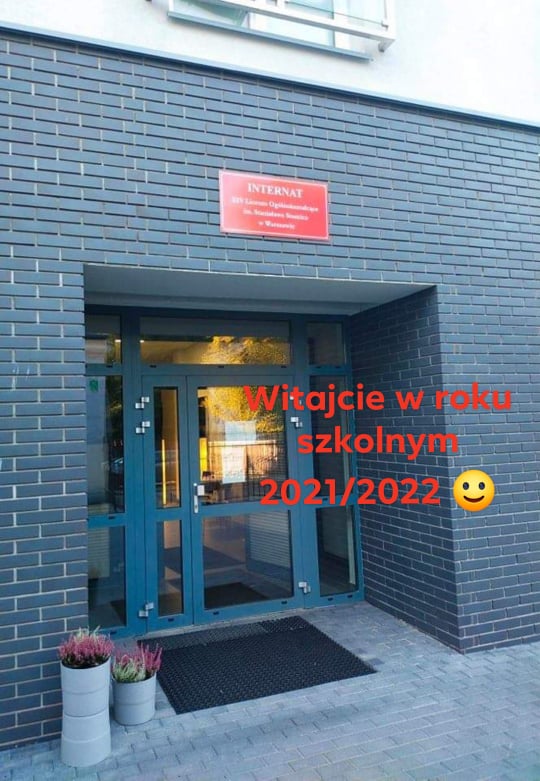Drzwi wejściowe internatu Liceum Ogólnokształcącego im. Stanisława Staszica z podpisem o treści Witajcie w roku szkolnym 2021/2022 i uśmiechem